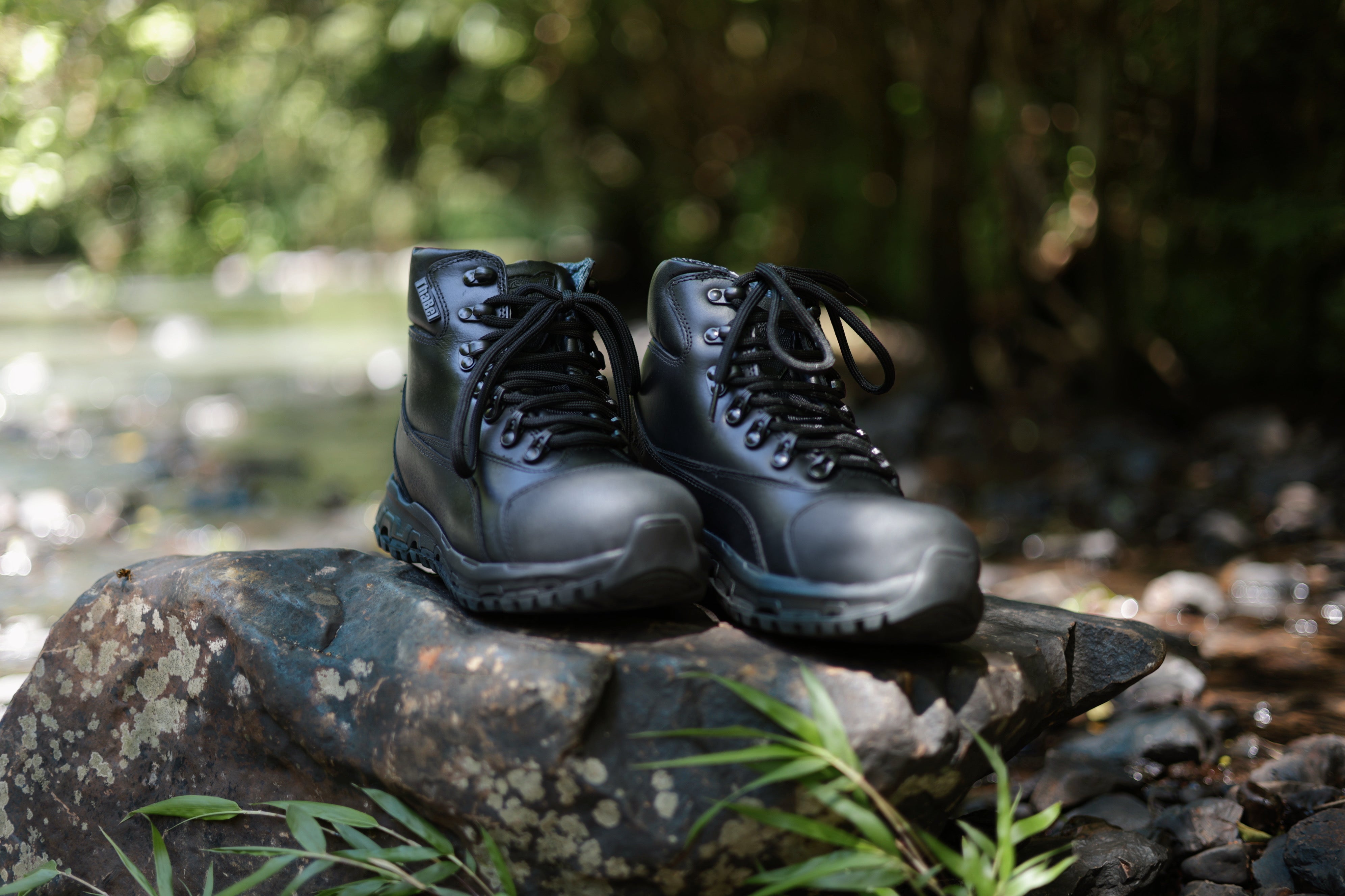 Botas táticas masculinas pretas sobre pedra ao ar livre, guia de Como Escolher Botas Táticas Masculinas Pretas.