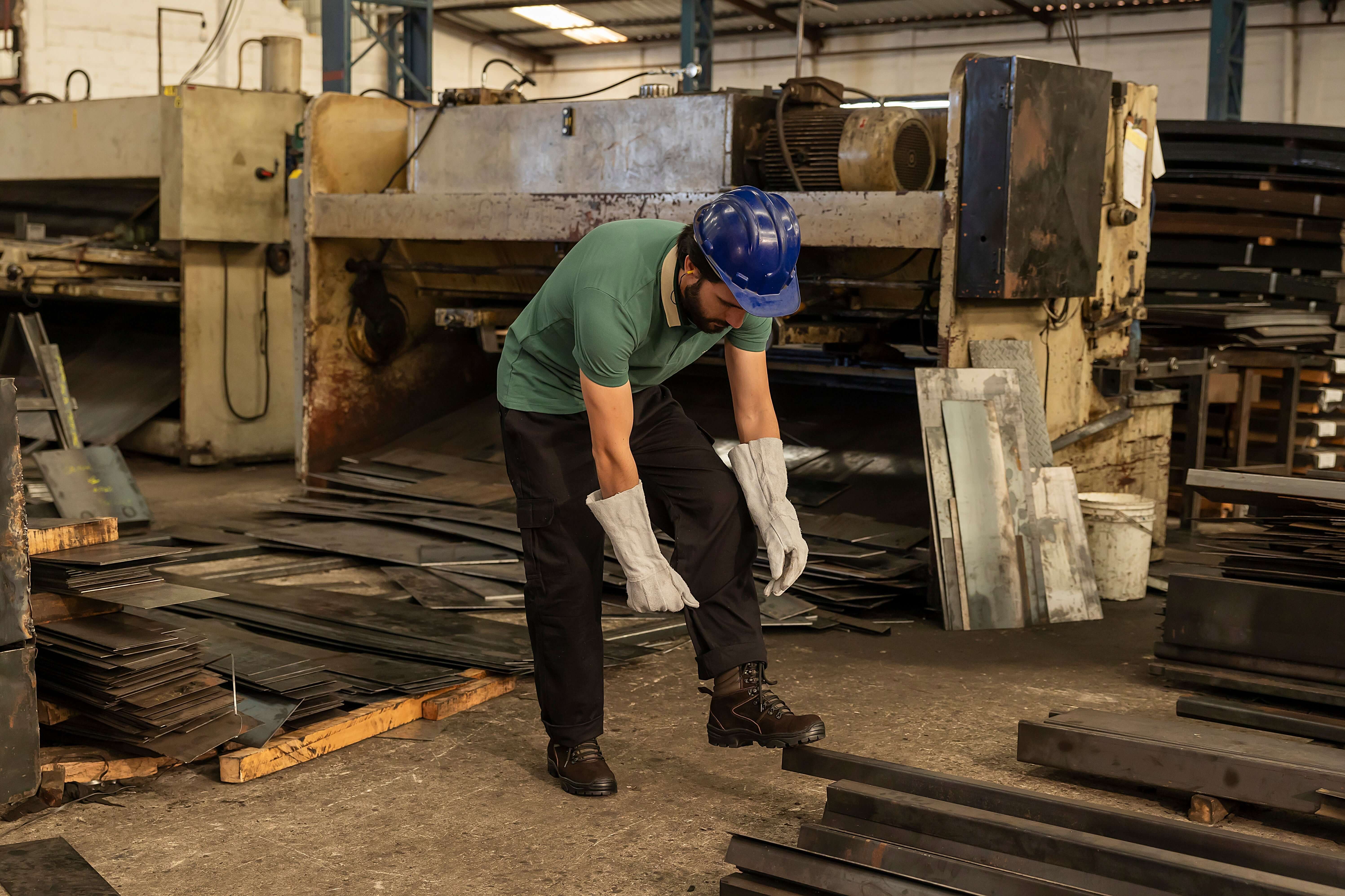 Trabalhador em fábrica usando coturno com CA para segurança