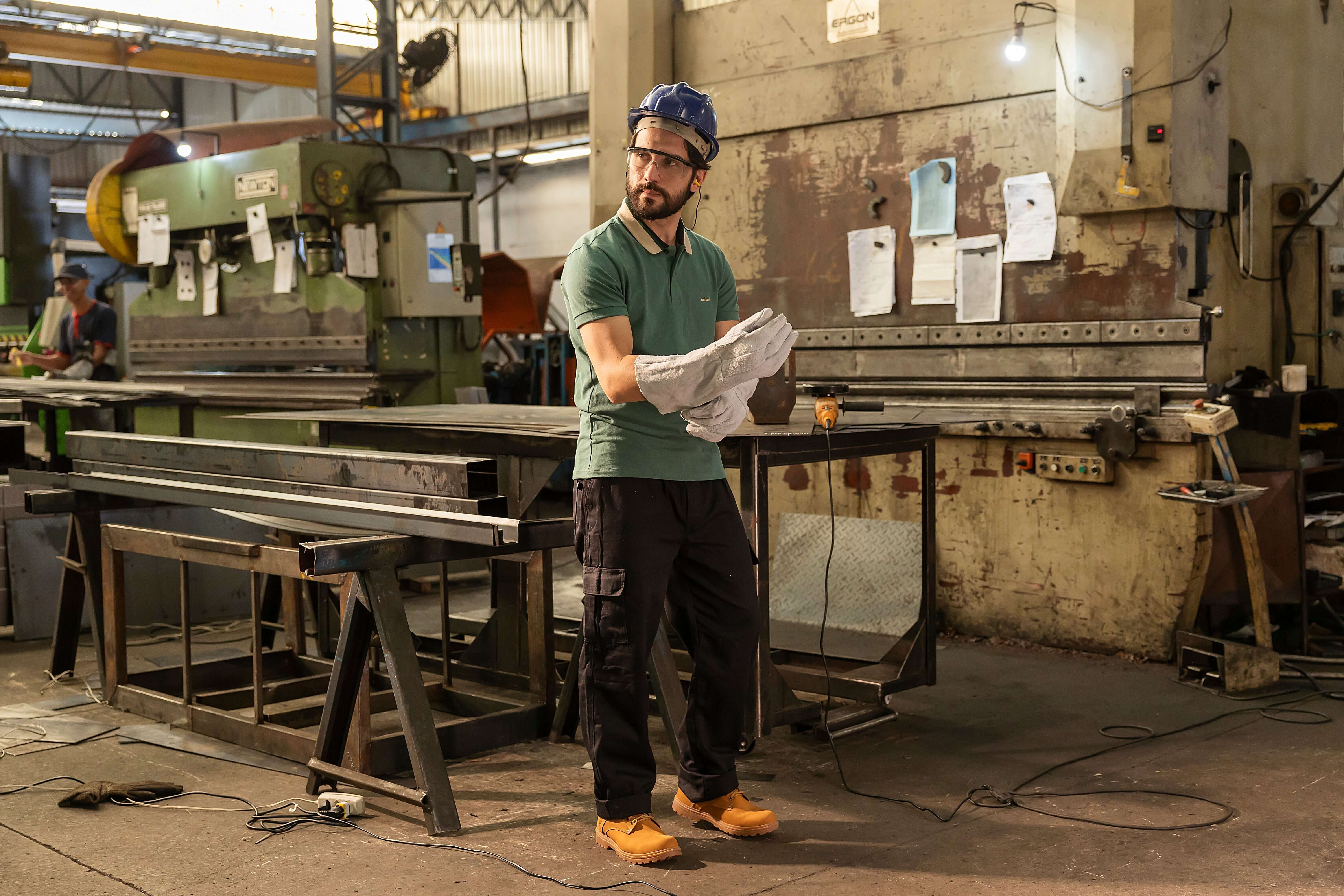 Homem em fábrica usando Botina de Segurança Masculina: Conforto e Proteção Diária