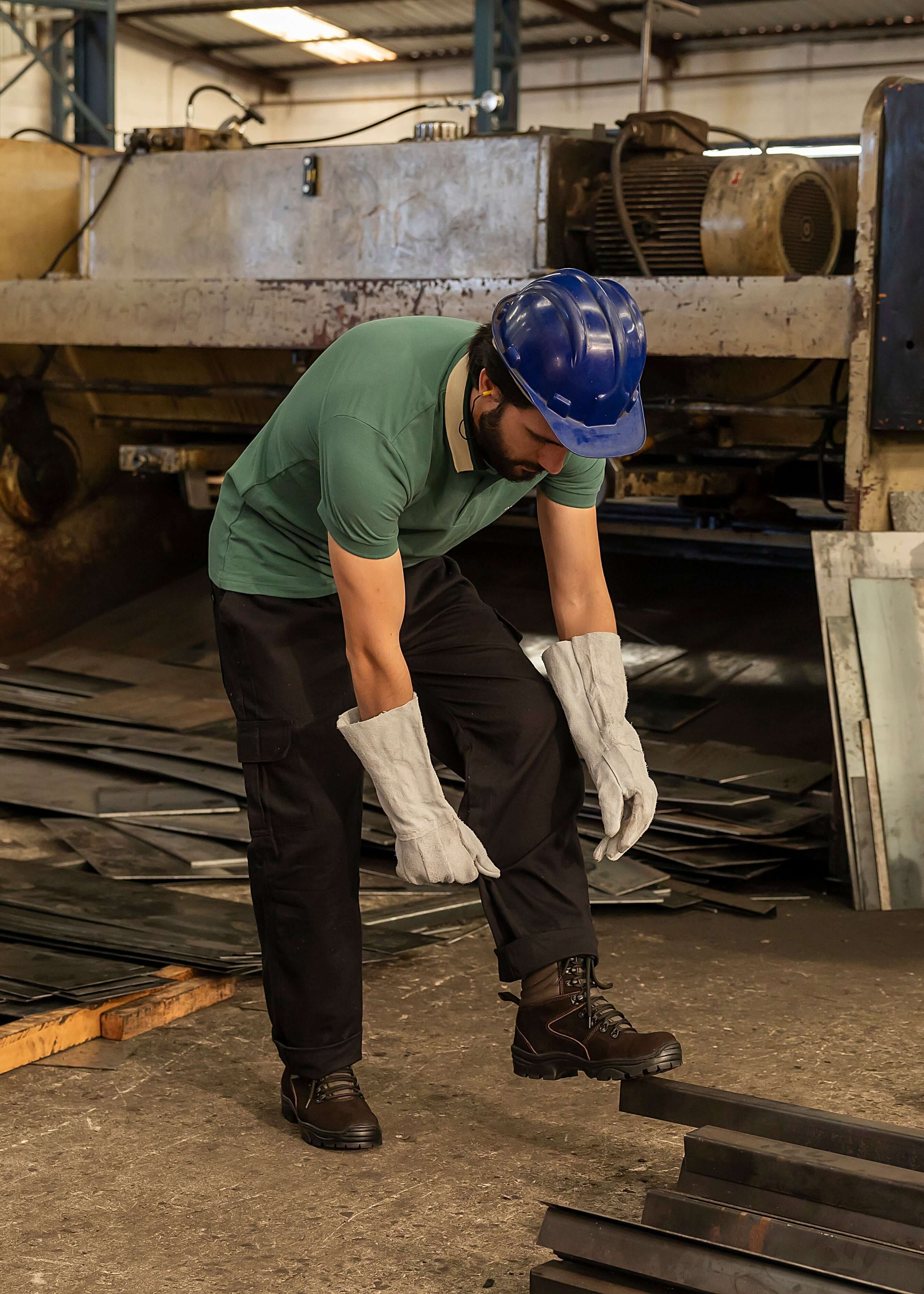 Trabalhador usando botina de segurança para trabalho em ambiente industrial.