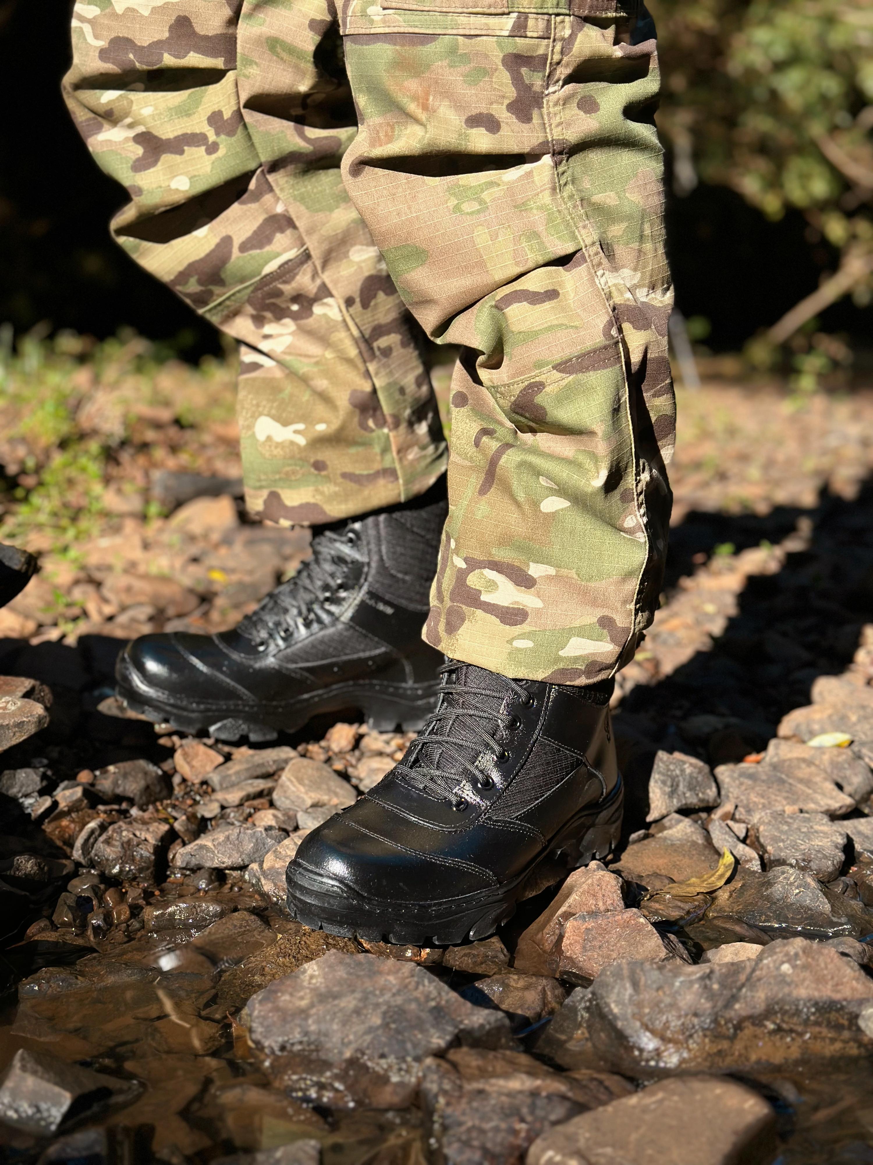 Bota tática impermeável em ambiente externo, destacando resistência e conforto em terrenos desafiadores.