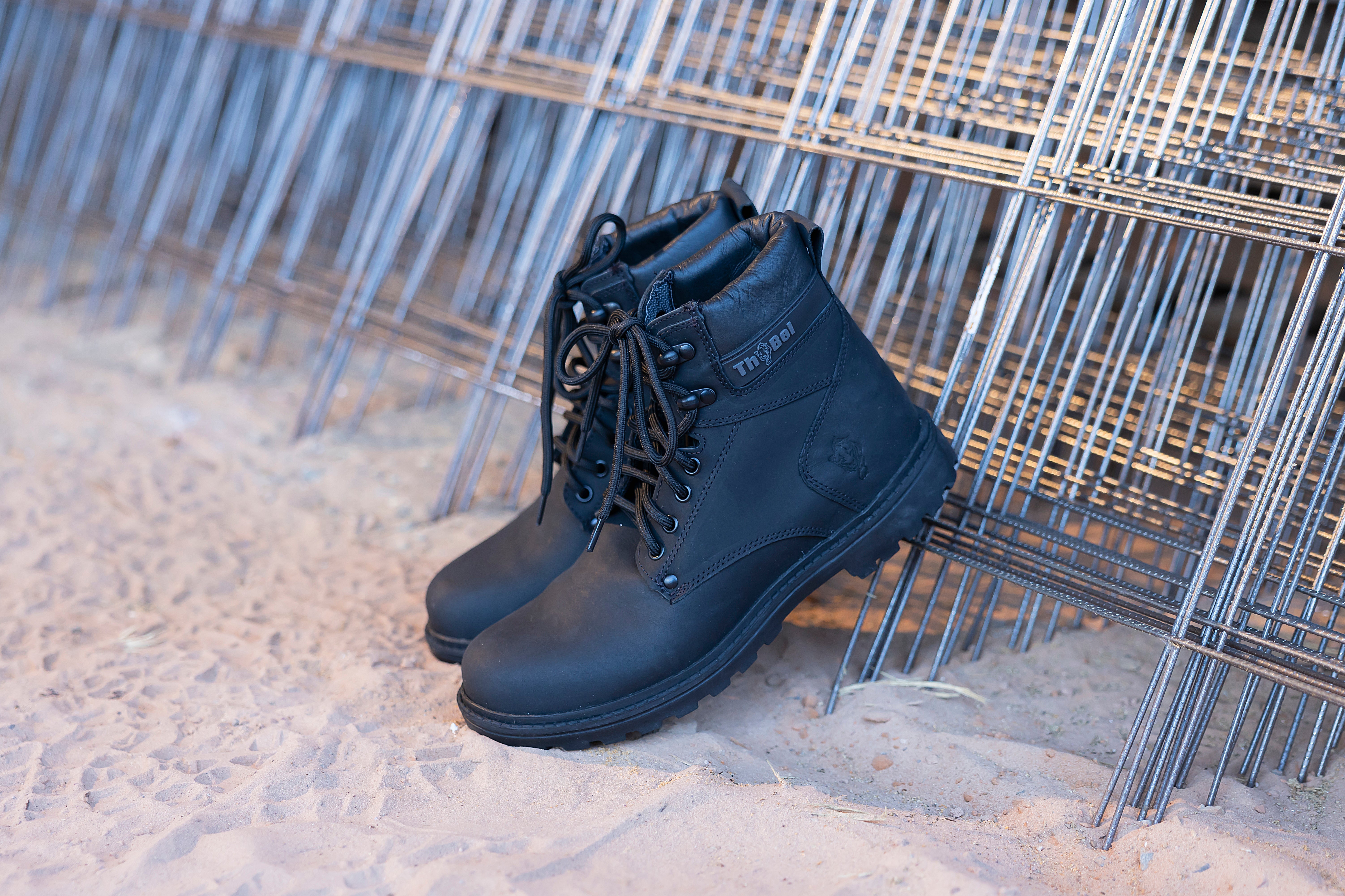 Bota com CA Masculina preta destacada em ambiente de construção, unindo estilo e conforto.