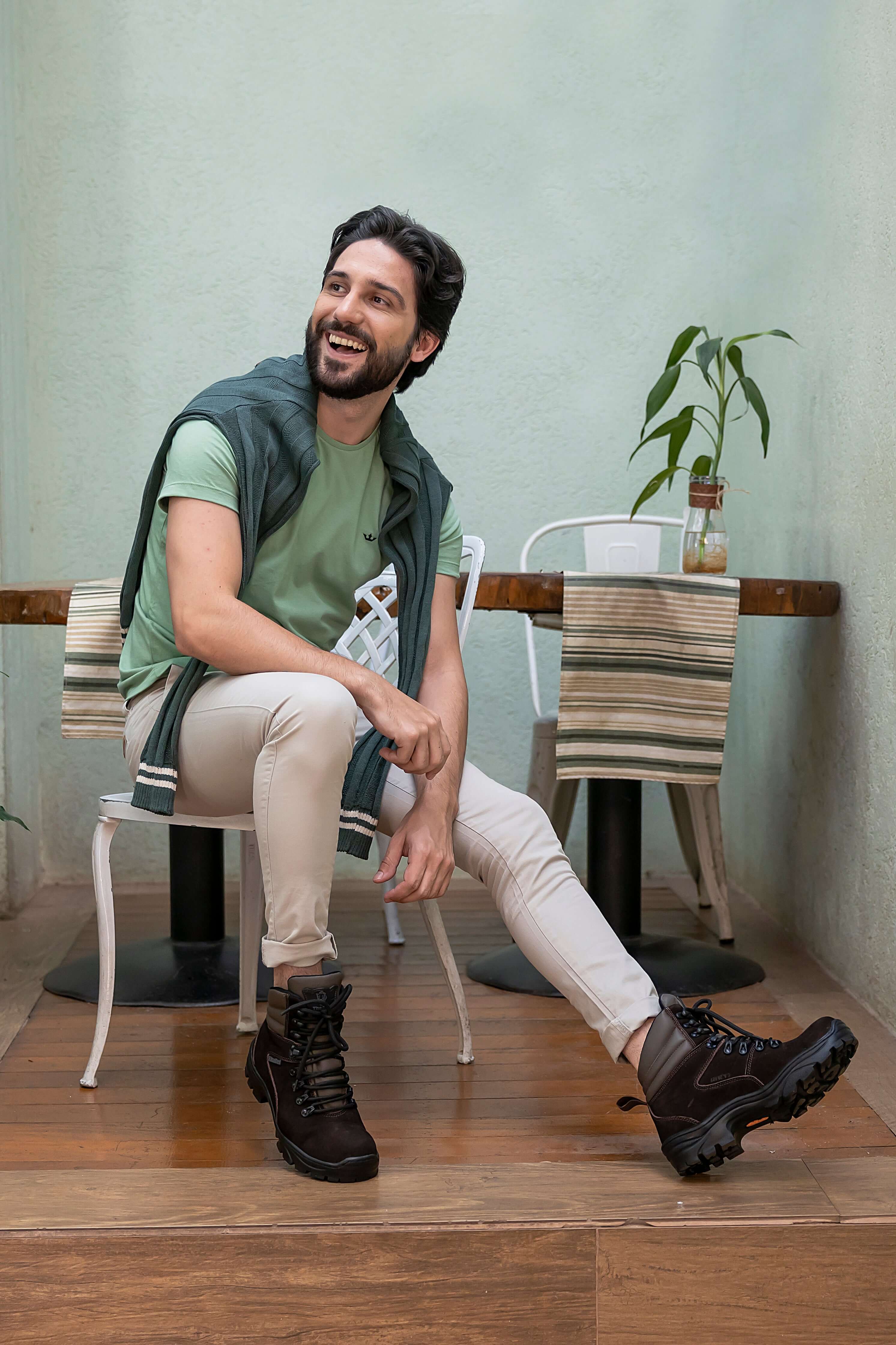 Homem usando botas ThaBel, a mais confiável marca de botas masculinas, sentado em um café.