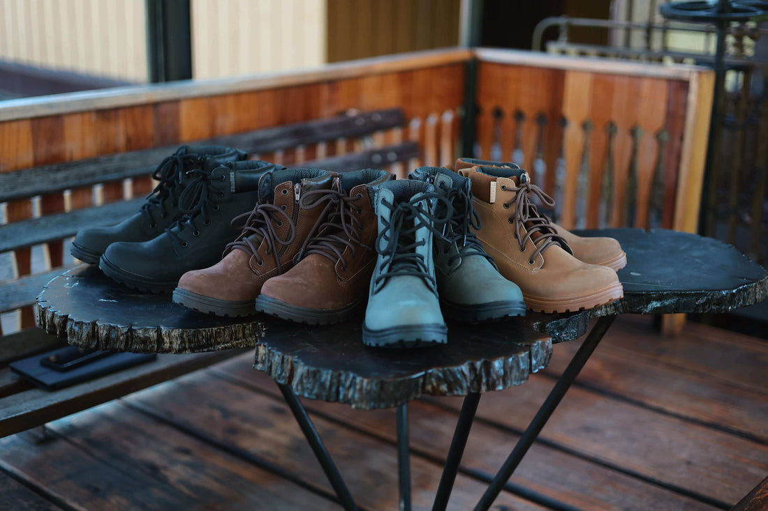 Melhores Botas para Trabalho: Conforto, Segurança e Estilo em diferentes cores dispostas sobre mesa de madeira