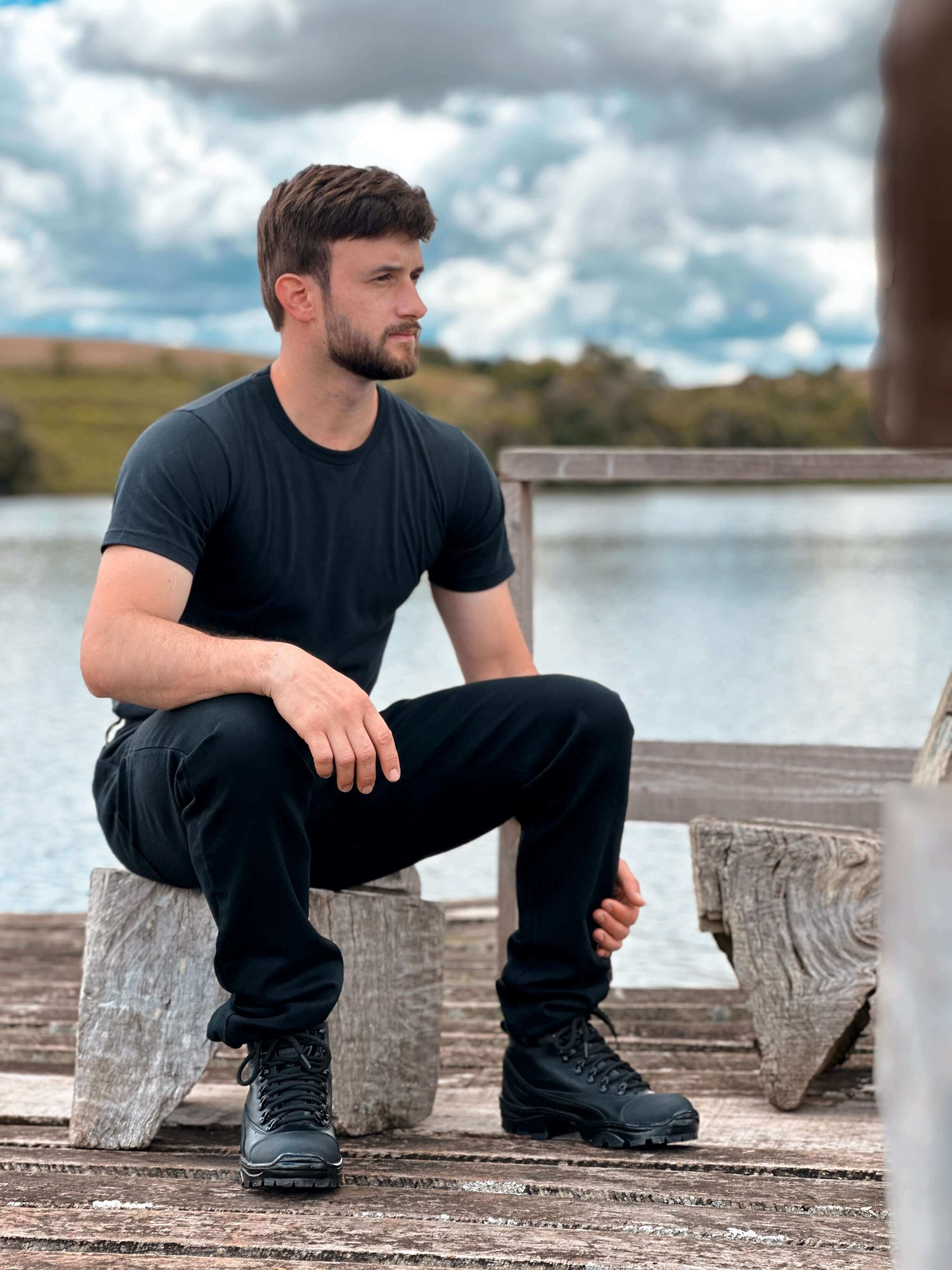Homem usando coturnos masculinos estilosos para durabilidade garantida em um cenário natural.